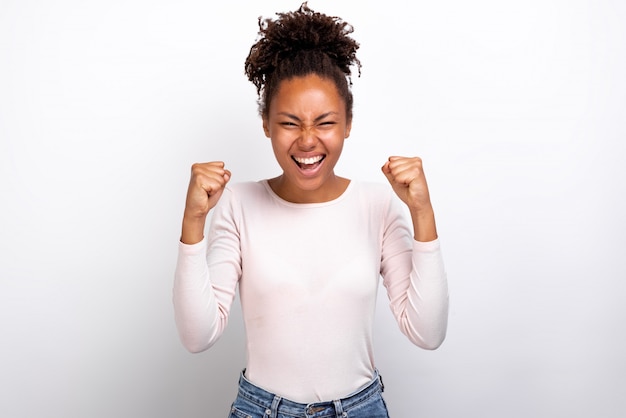 Excited woman raised hands in success gesture 