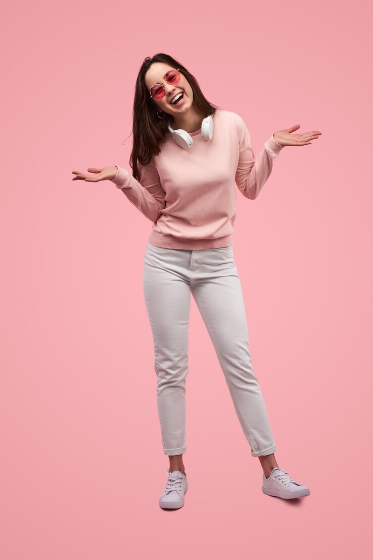 Photo excited woman shrugging shoulders and smiling in studio