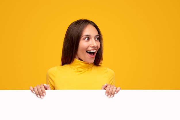 Excited woman with blank white poster