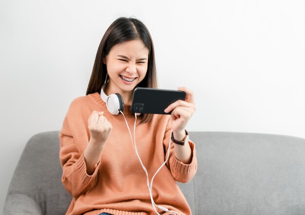 Excited young Asian woman wear white headphone