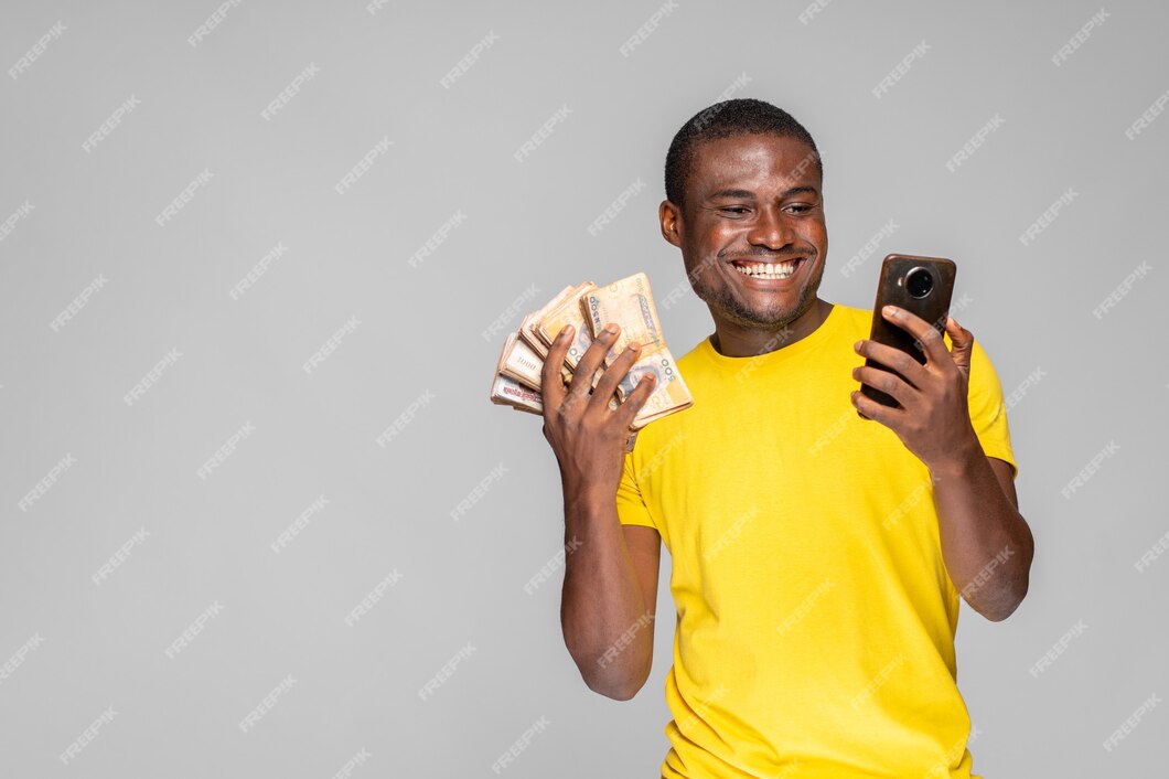 Premium Photo | Excited young black man holding money and using his phone