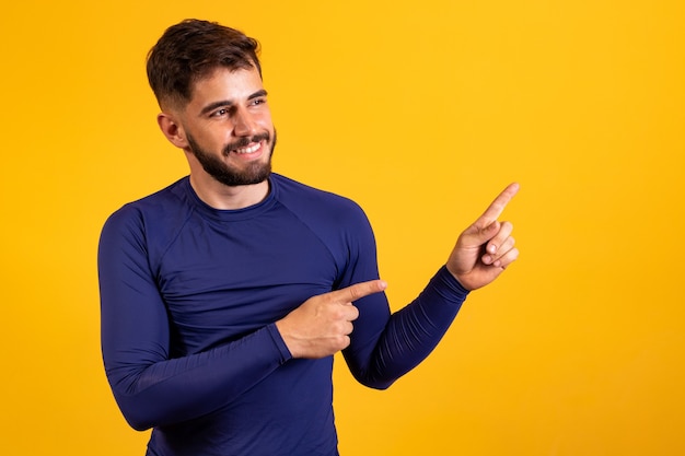 Excited young boy pointing to free space for text.