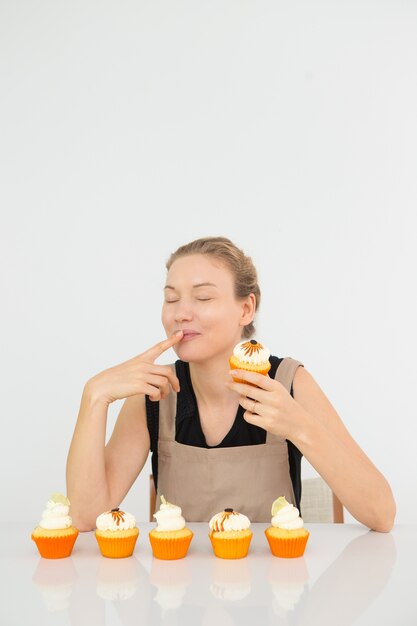 Excited Young Caucasian Woman Trying Cupcake