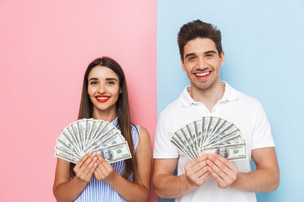 Excited young couple standing isolated