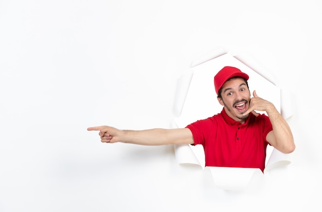 Excited young courier in red uniform on white