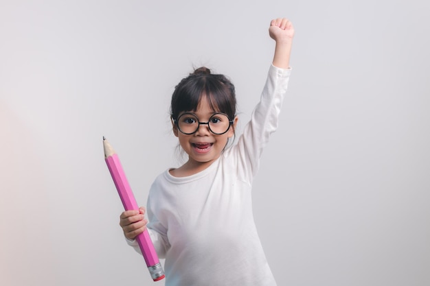 Excited young girl kid holding up big pencils in her handsBack to school