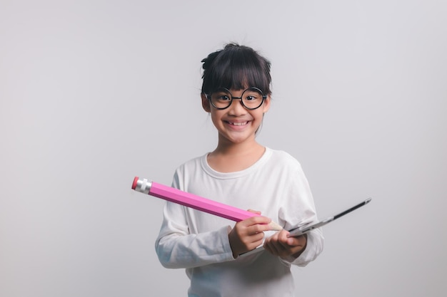 Excited young girl kid holding up big pencils in her handsBack to school