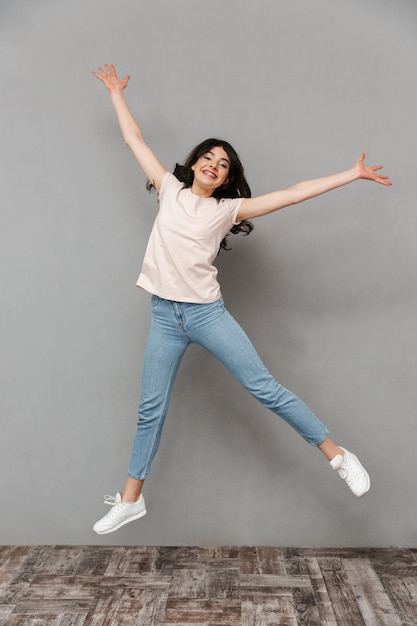 Excited young lady jumping isolated