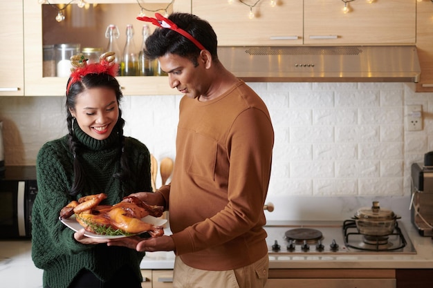 Excited young man looking at fried chicken his wife cooked for christmas dinner