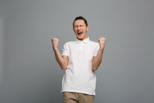 Excited young man make winner gesture.