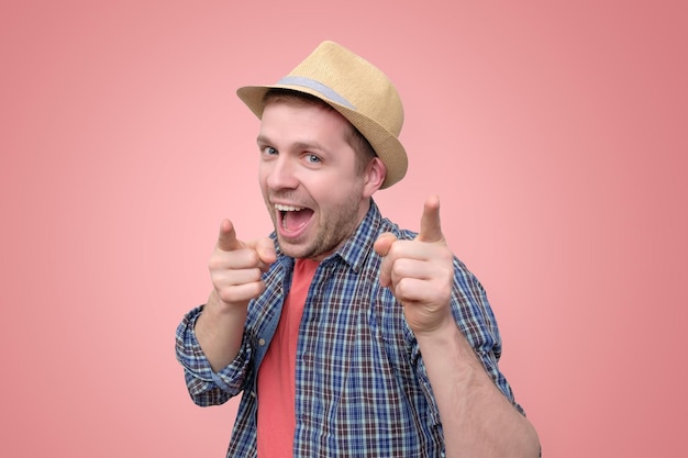 Excited young man pointing fingers at camera