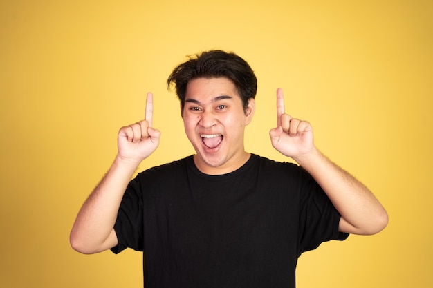 Excited young man with two fingers pointing up