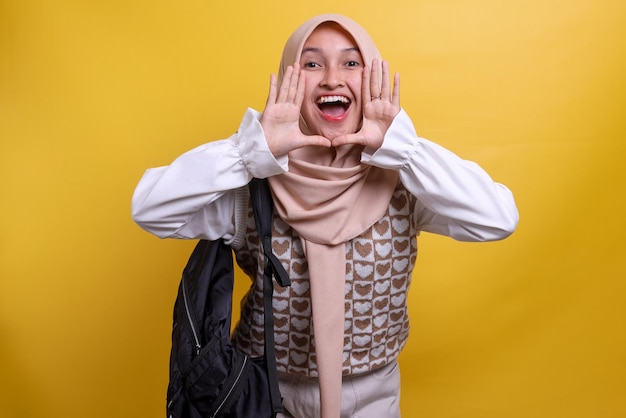 Excited young muslim female student college wearing hijab and carrying backpack screaming like in me