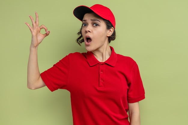 Excited young pretty delivery woman gesturing perfect sign 