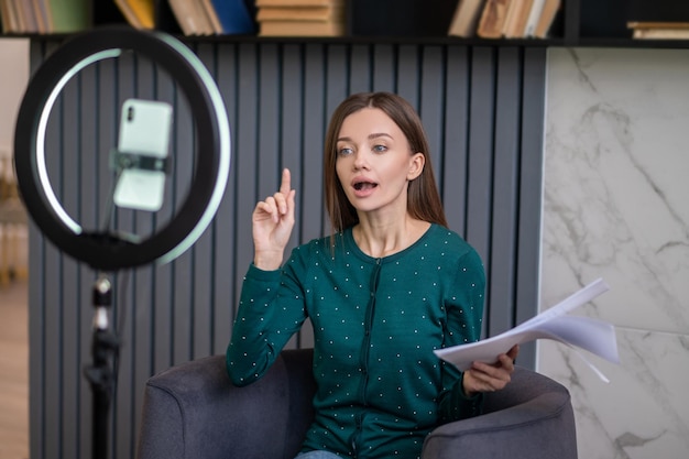 Excited young woman conducting an online tutorial