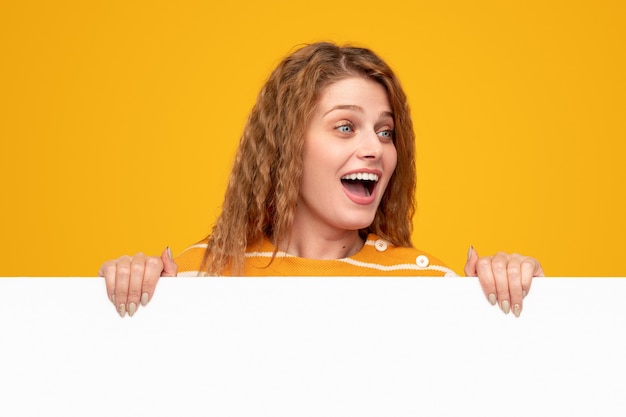 Excited young woman demonstrating empty banner