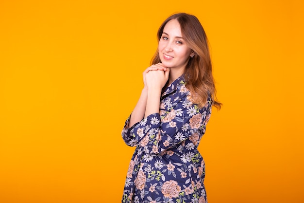 Excited young woman with curly hair in home wear pajama, widely smiling having fun