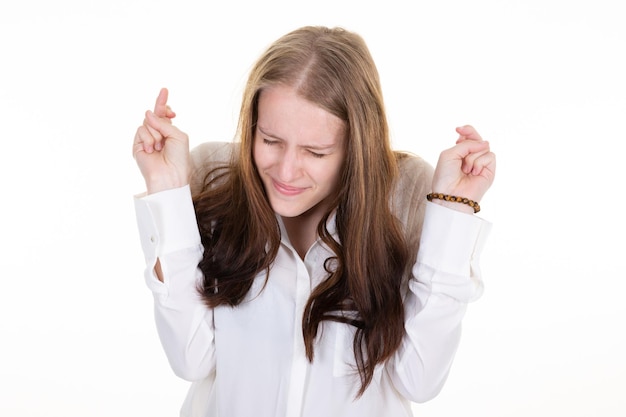 Excitement charming young woman cross fingers good luck closed eyes smiling gladly make wish dream party went well in white background