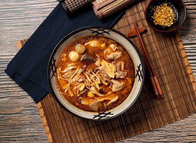 Foto exclusieve pittige pot met stokjes geserveerd in pot geïsoleerd op tafelblad van taiwan eten