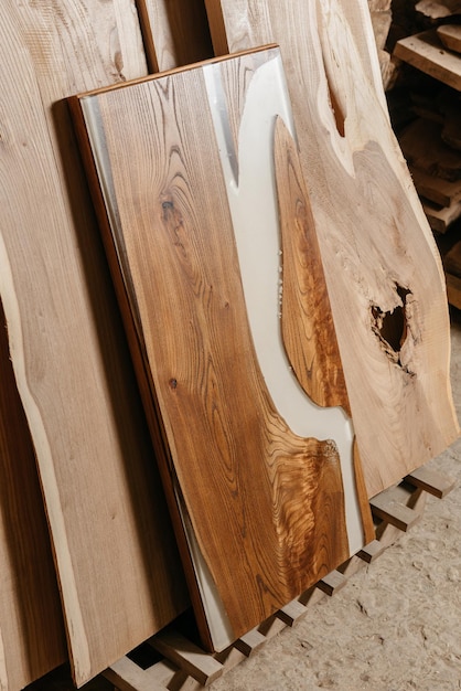 Эксклюзивный стол ручной работы из массива дерева и эпоксидной смолы на фоне деревянных досок