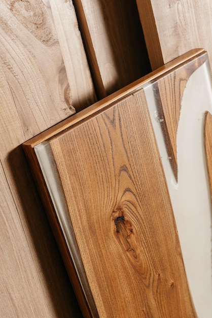 Эксклюзивный стол ручной работы из массива дерева и эпоксидной смолы на фоне деревянных досок