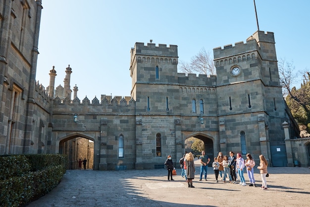 Excursion to the medieval castle, the palace, the stone road, the courtyard in the palace, people listen to the guide