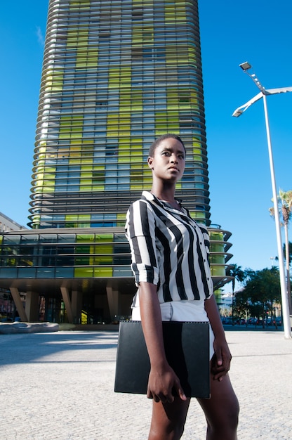 executive black woman in business area in a city under blue sky