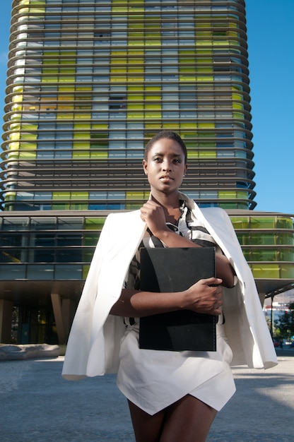 executive black woman in business area in a city under blue sky