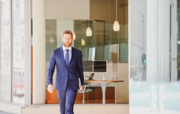 Executive businessman portrait of ceo near modern office in suit happy leader standing in front of c