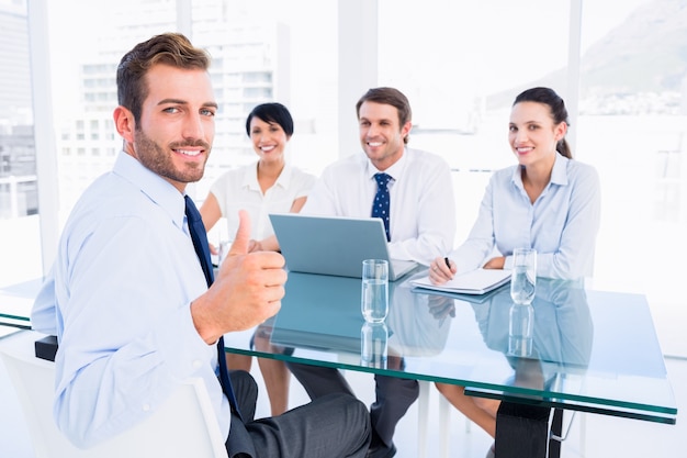 Executive gesturing thumbs up with recruiters during interview