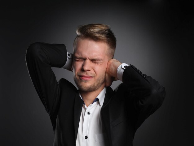 Executive man having head ache isolated on gray background