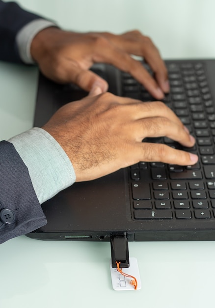 Executive man typing and  a pen drive inserted in a computer