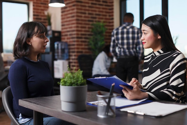 Executive manager recruiting entrepreneur asking career questions during interview meeting in startup business office. Businesswoman hiring candidate discussing human resources job offer