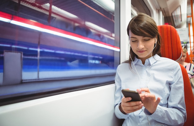 Executive utilizzando il telefono cellulare durante l'ascolto di musica