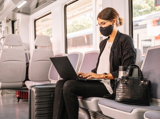 Foto la donna esecutiva utilizza un computer portatile sul treno