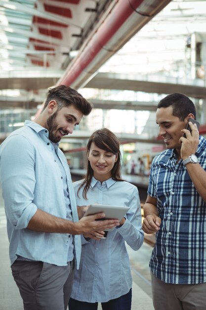 Executives discussing over digital tablet on platform