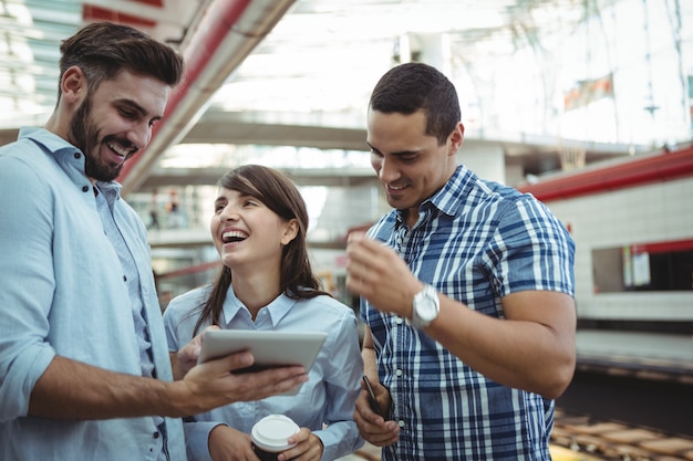 Executives discussing over digital tablet on platform