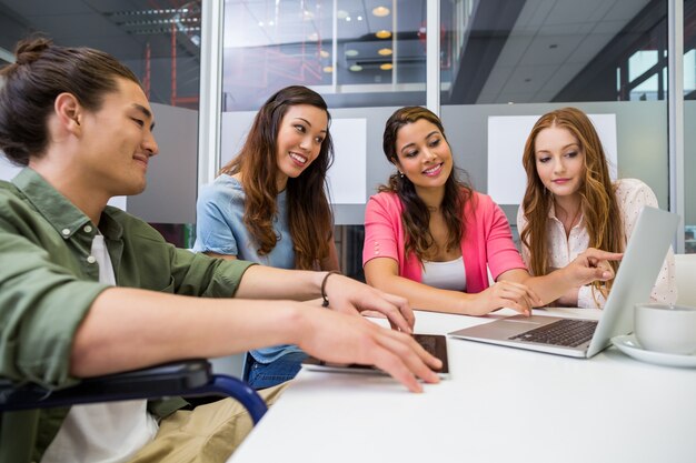 Executives discussing over laptop in conference room