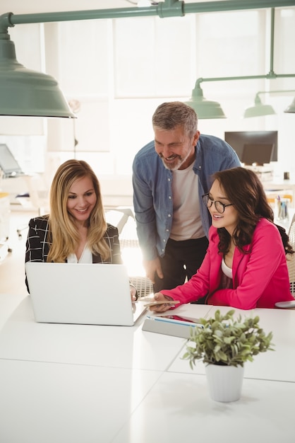 Executives discussing over laptop at desk