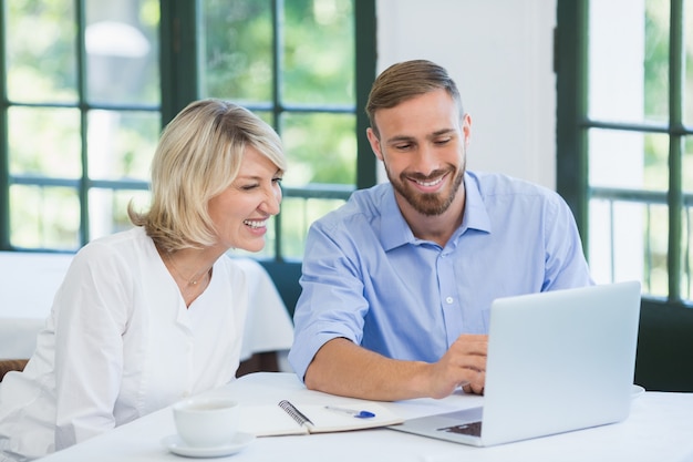 Executives discussing over laptop