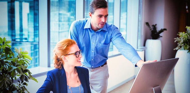 Executives having discussion over personal computer at desk