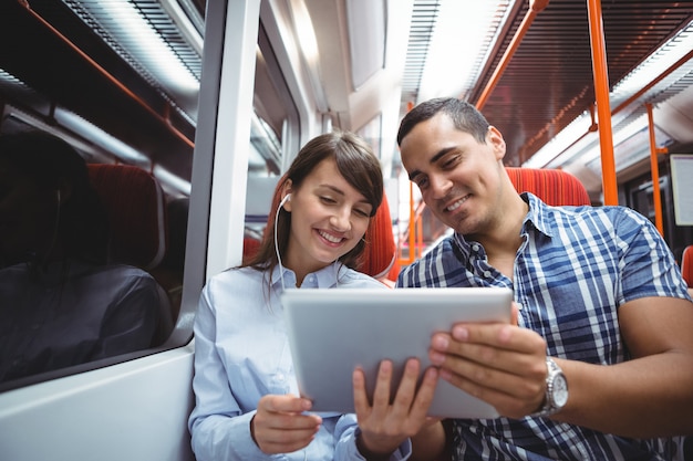 Executives using digital tablet travelling in train