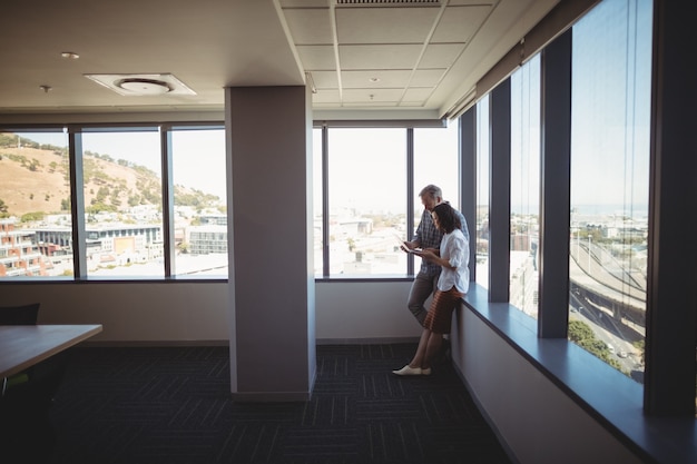 Executives using laptop near the window