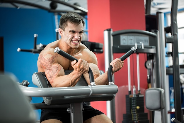 Exercise for biceps. young bodybuilder doing heavy weight exercise for biceps