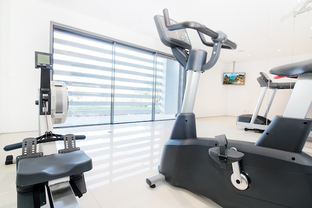 Exercise bike and rowing simulator in a modern luxe gym. Indoor.