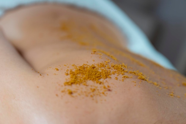 Exfoliating massage with brown sugar Woman back and sugar detail High quality photo