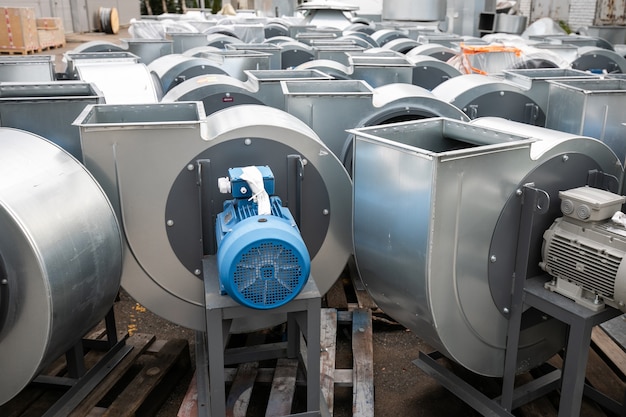 Exhaust snail fan with installed electric motor for air ventilation in a factory storage area