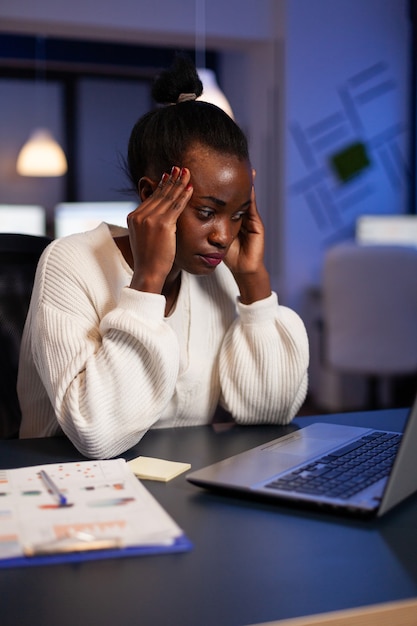 Exhausted african american businesswoman massage forehead having headache