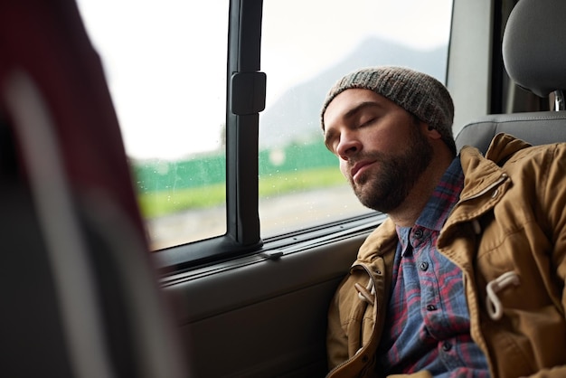 Измученный после долгих путешествий Снимок красавца, спящего на заднем сиденье путешествующего автомобиля