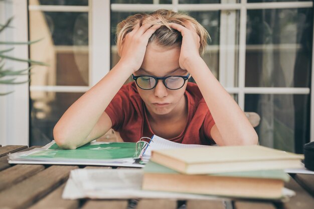 写真 疲れ果てた少年が本を見ている